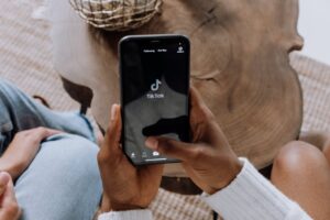 Una persona que abre TikTok en su teléfono para representar la prohibición de TikTok fuente de la imagen: https://www.pexels.com/photo/person-holding-black-android-smartphone-5081930/