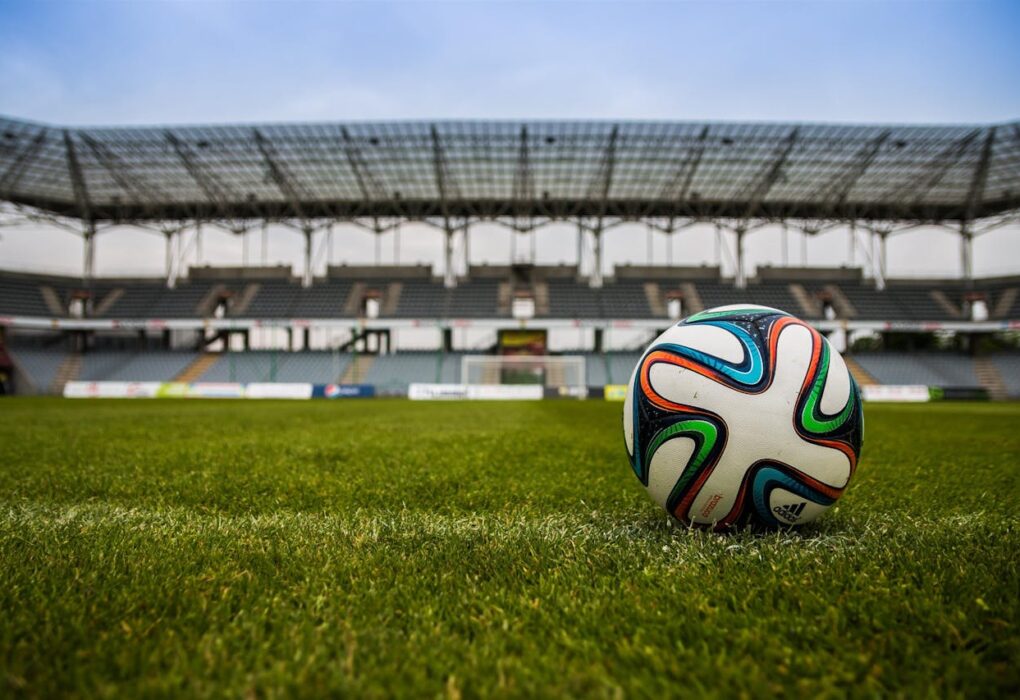 Un balón de fútbol en el campo verde de un estadio de fútbol para representar uno de los eventos deportivos más importantes de 2025.